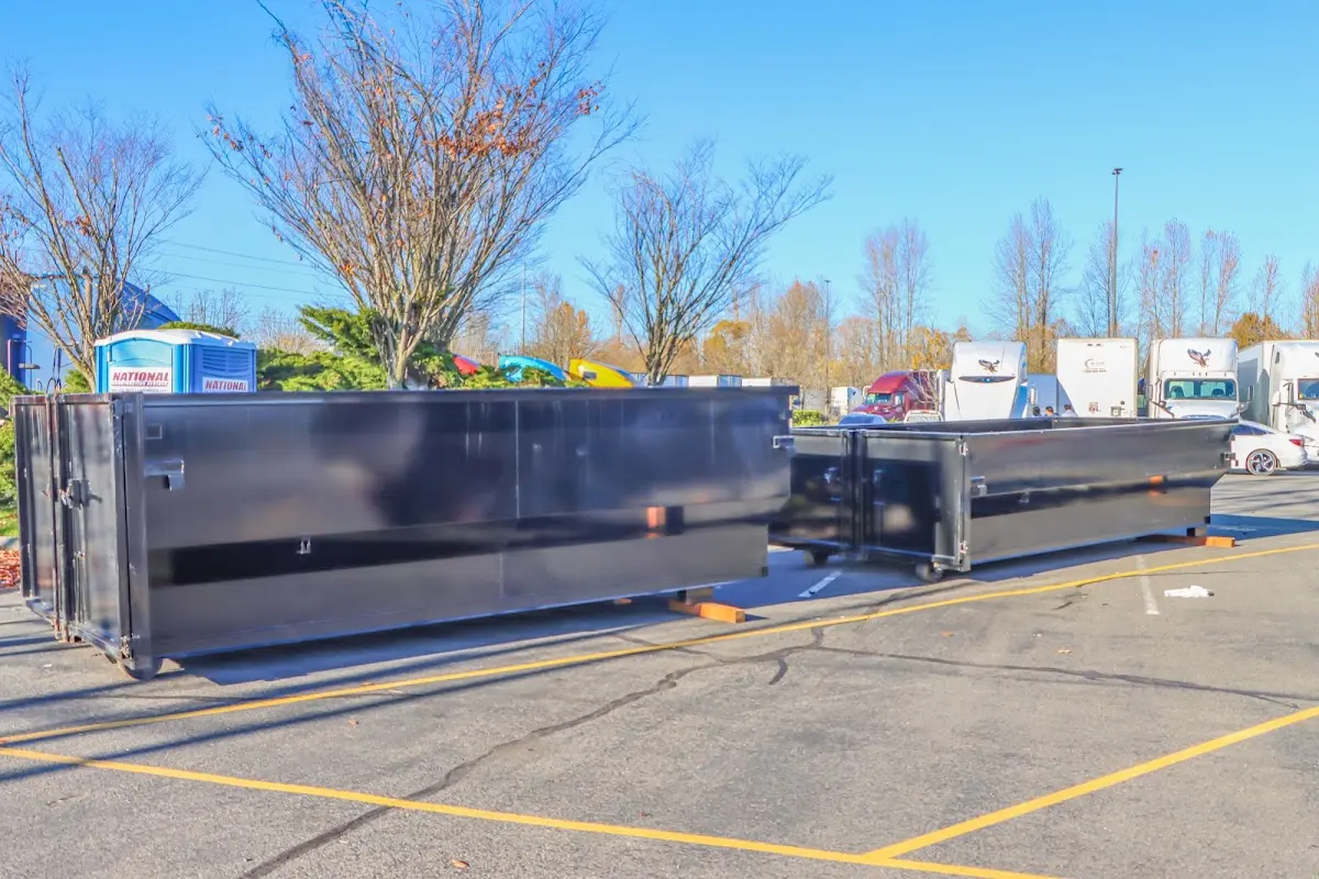 Professional dumpster rental service with roll-off container on residential driveway in Mendham